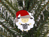 Decorative sheep ornament with a Santa hat on a Christmas tree.