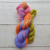 Two skeins of colourful yarn tied together on a wooden surface